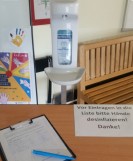 Foto: Desinfektionsbehälter und Tisch mit Liste zum Eintragen