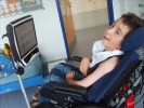 Foto: Schüler im Rollstuhl, an dem ein Sprachcomputer befestigt ist.