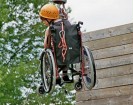 Foto: Schüler in einem Rollstuhl im Hochseilgarten, aufgehängt in einer Seilvorrichtung.