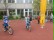 Das Foto zeigt Schüler beim Fahrradfahren auf dem großen Hof.