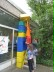 Das Foto zeigt einen Schüler auf einer Leiter, der große farbige Baustein-Elemente aufeinander stapelt.