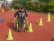 Das Foto zeigt einen Schüler, der in einem Rollstuhl Slalom fährt.