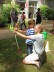 Das Foto zeigt eine Lehrerin, die einem Jungen bei der Haltung des Bogens hilft.