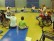 Das Foto zeigt Schülerinnen und Schüler, die in der Sporthalle auf Matten Bewegungen aus der Geschichte nachstellen.