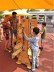 .Das Foto zeigt Erwachsene und Kinder beim Spielen an großen Holzspielzeugen.