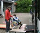 Foto: Rollstuhlfahrer beim Einsteigen über eine Rampe in einen Stadtbus