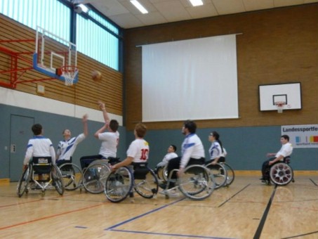 Foto: Rollstuhlfahrende Basketballspieler und Spielerinnen in einer Turnhalle