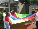 Foto: Schülergruppe und Lehrer an Schwungtuch mit Ball
